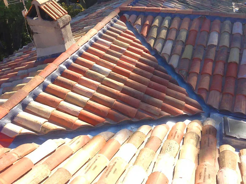 Artisan couvreur intervenant sur une toiture en tuiles